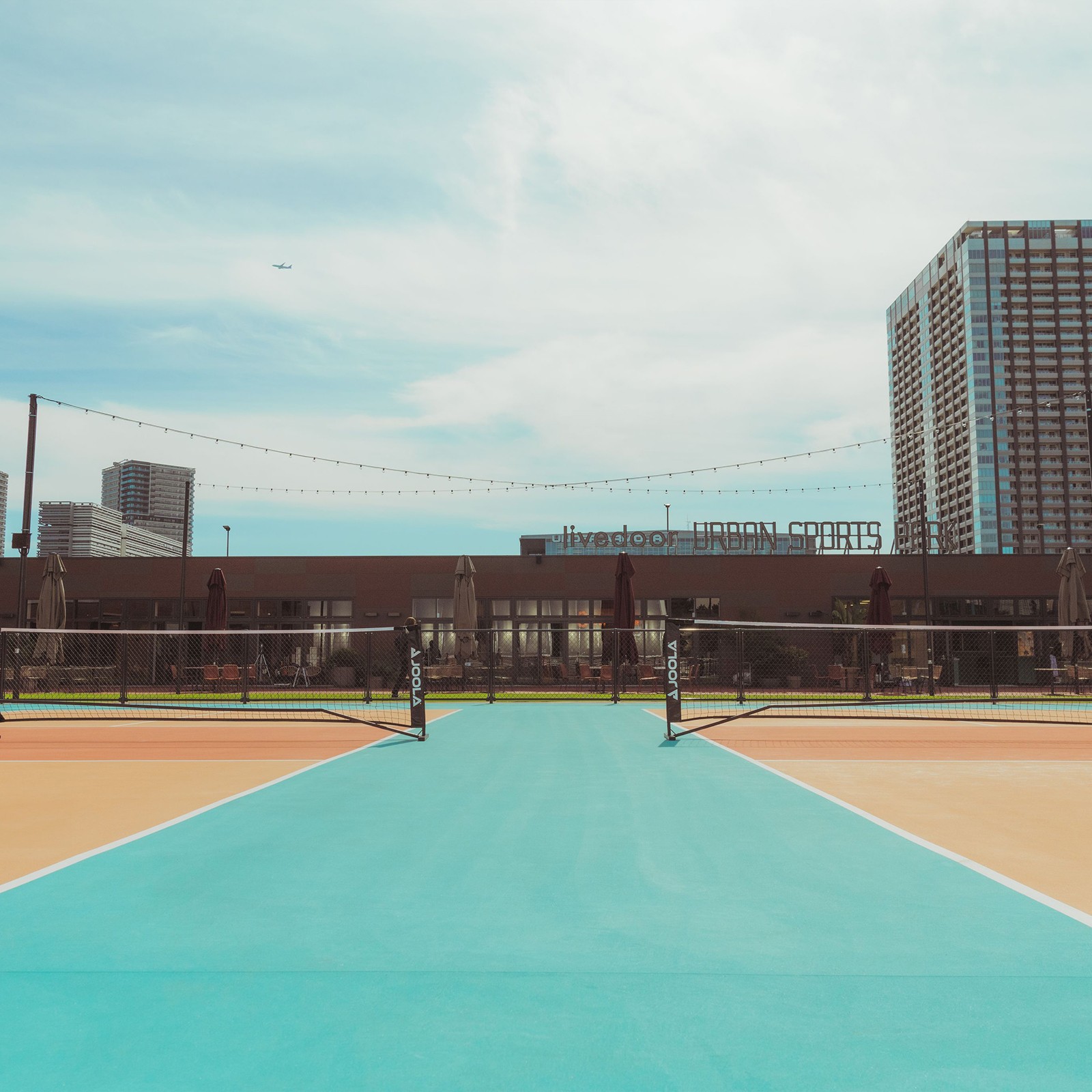 The pickleball courts at livedoor URBAN SPORTS PARK, the park's name on the roof beyond